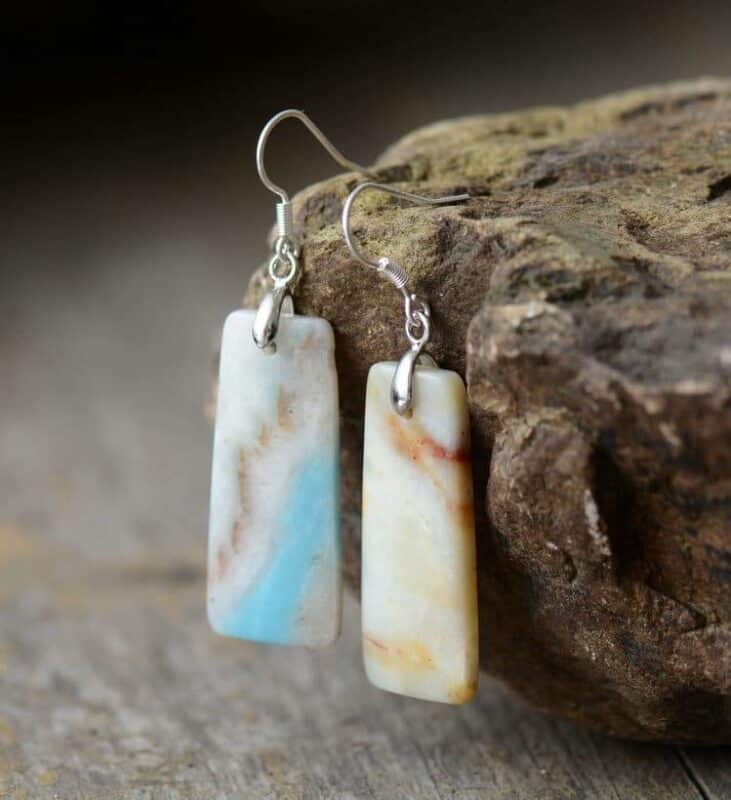 paire de boucles d'oreilles avec pendentif plaque de pierre marbrée bleu, blanche et jaune accroché grâce aux fermoirs argents à une pierre