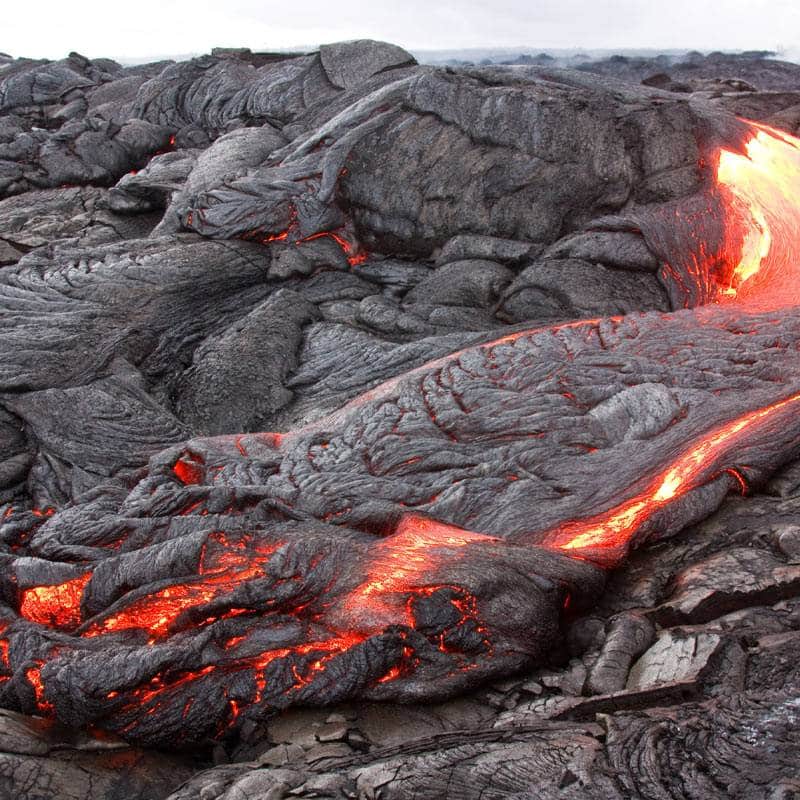 magma qui coule entre des roches volcaniques