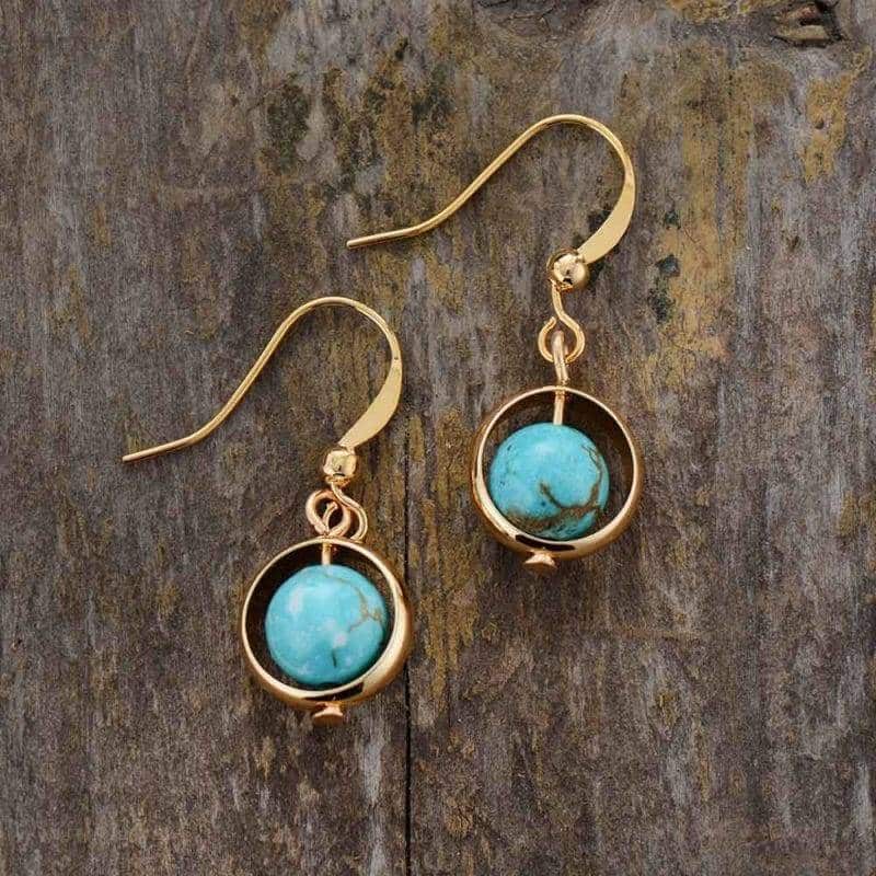 paire de boucles d'oreilles monture dorée avec une perle de pierre turquoise au centre