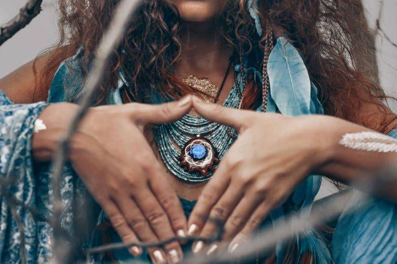 Femme chaman portant des bijoux faisant un geste avec ses mains