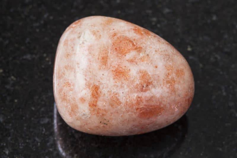 Pierre de soleil polie sur fond en granit
