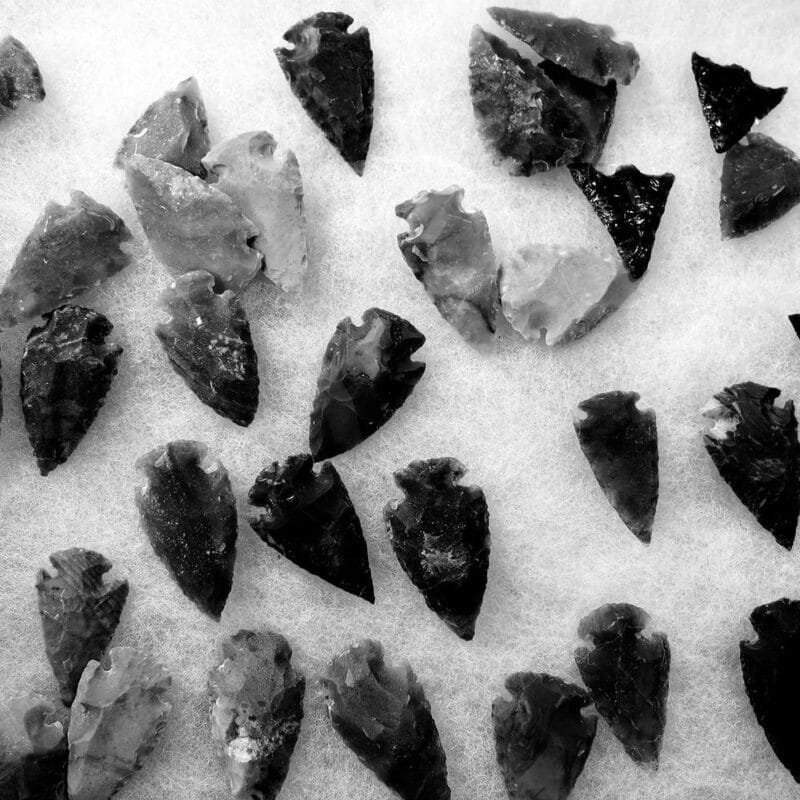 fragments en forme de fleches noires en obsidienne sur fond blanc