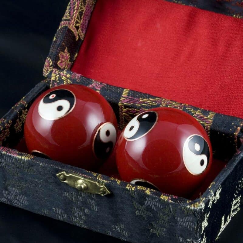 deux boules chinoises rouges avec motif ying et yang dans un étui noir