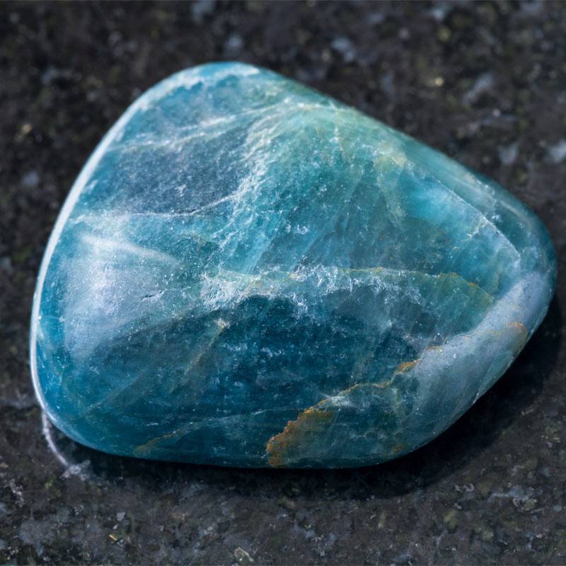 grosse pierre d'apatite bleue posé sur fond gris foncé