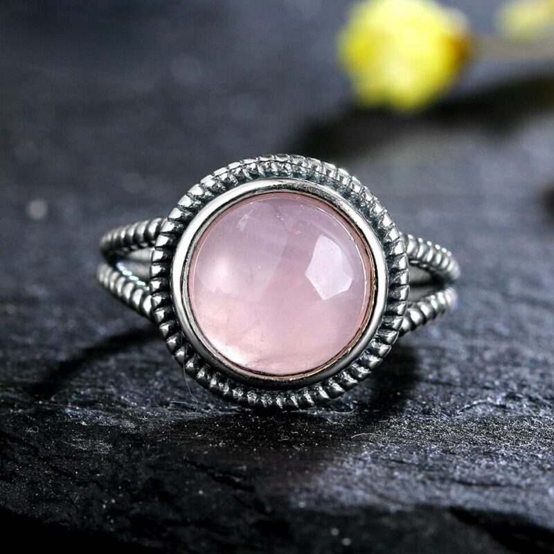 bague argent gravure avec pierre rosse quartz ronde posé sur une table en pierre