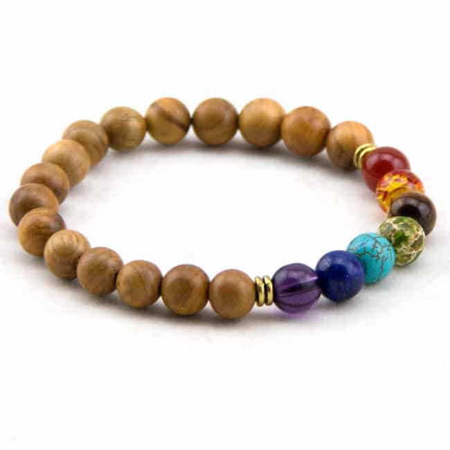 Bracelet sept chakras à perles en bois naturel pour homme sur fond blanc.