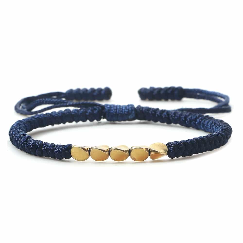 Bracelet tressé et perles de cuivre tibétain fait à la main sur fond blanc