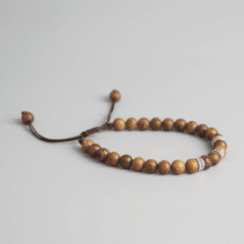 Bracelet porte-bonheur bouddhiste tibétain tressé à la main avec perles en bois sur fond gris
