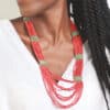 Collier tibétain artisanal long à perles rouges porté par une femme avec un t-shirt blanc