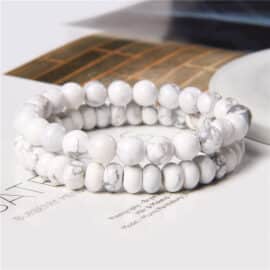Lot de deux bracelets à perles rondes en pierre naturelle pour homme et femme sur fond blanc et marron