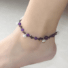 Bracelets de cheville à fleur et perles en pierre de jade sur une cheville sur fond gris
