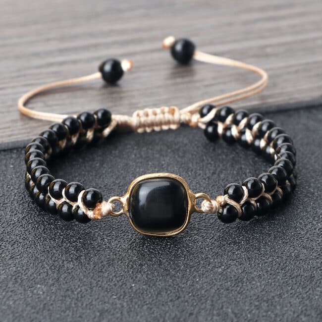 Bracelet en perles d'onyx noires brillantes sur fond gris
