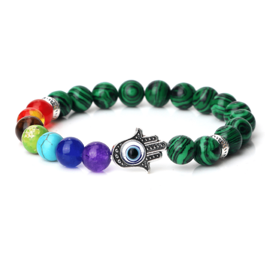 Bracelet septs chakras en perles de malachite avec main et oeil sur fond blanc