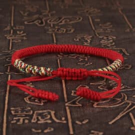 Bracelet Tibétain Rouge et Ajustable en Coton sur fond marron