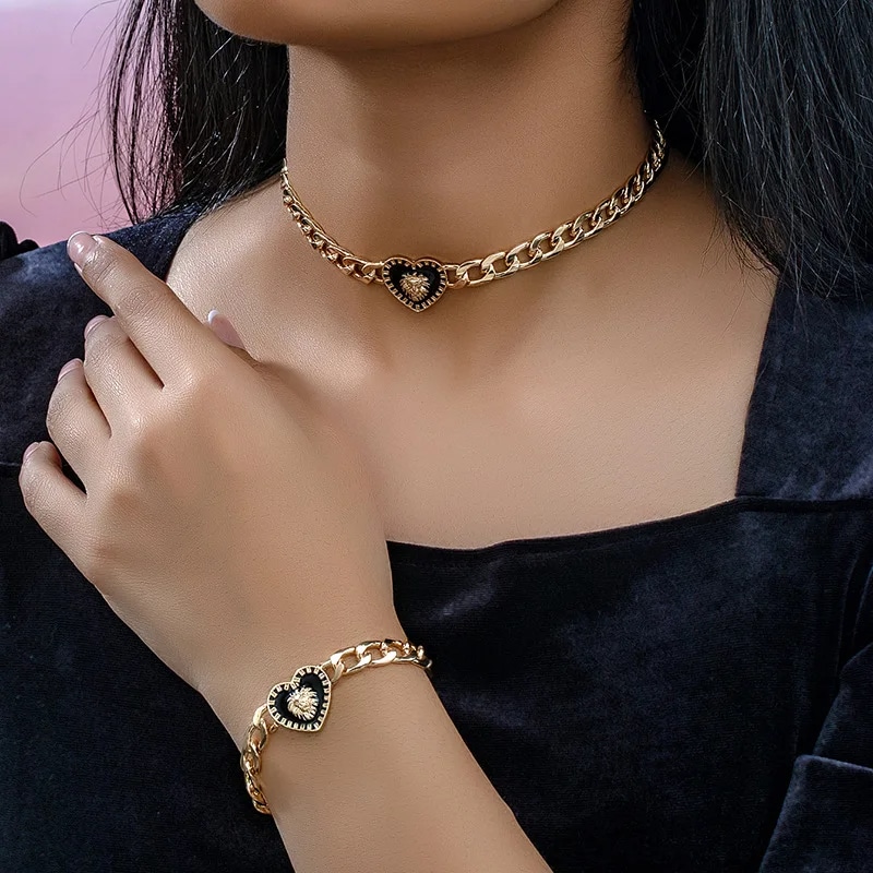 Collier Cœur de Lion Doré en Métal avec Bracelet sur une femme avec un haut noir