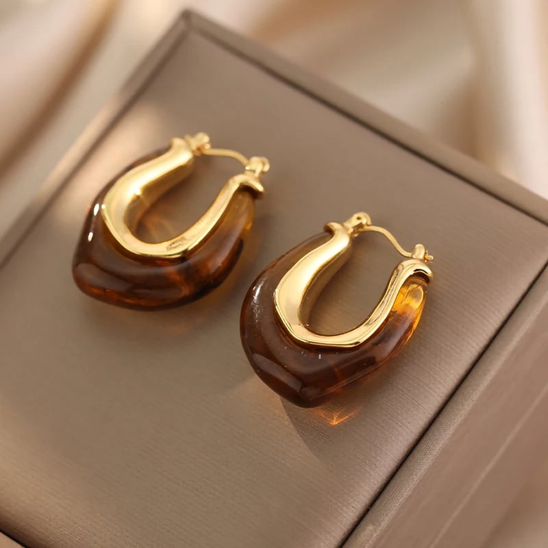 Boucles d'Oreilles Ambre en Forme de U sur une boîte grise