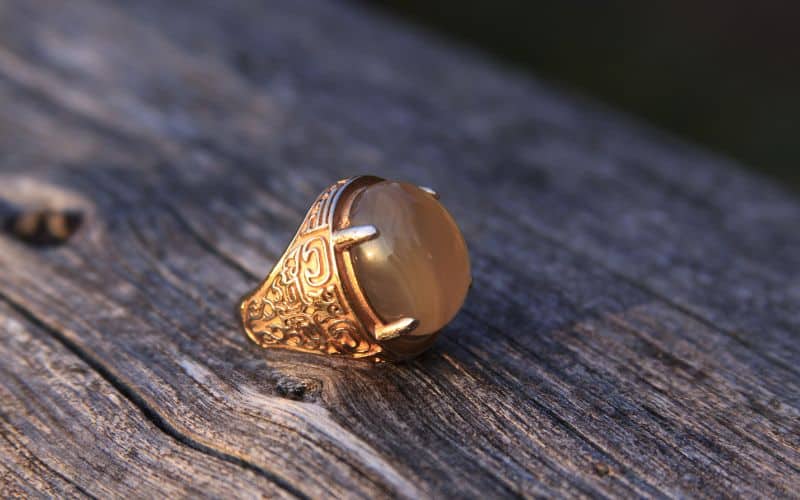 Grosse bague en or doré sertie d'une grosse pierre, style chevalière.